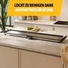 A long, flat electric grill plate is placed on a kitchen countertop, with some sliced zucchini on a cutting board on top of the grill. The background shows kitchen cabinets and a plant. Voir les images du produit