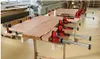 A workshop setting where wooden planks are being glued together and clamped. Produktbild-Vorschau