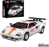 A white sports car model made of building blocks, with orange racing stripes and various decals, displayed on a white background. A box showing the same car model is visible in the upper left corner. Podgląd zdjęcia produktu