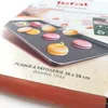 A baking tray with macarons on it, placed on a wooden surface, with packaging in the background. Voir les images du produit