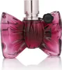 A close-up studio shot of a pink bow-shaped perfume bottle with a silver cap. Voir les images du produit