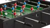 A close-up view of a foosball table with players and a ball. Anteprima dell’immagine prodotto