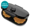A black waffle maker with two heart-shaped waffles inside, on a white background. Podgląd zdjęcia produktu