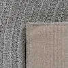 A close-up view of a rug, showing both the textured top pile and the woven backing. Voir les images du produit