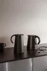 Two black thermoses and a black mug on a dark countertop. Voir les images du produit