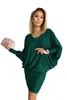 A woman is posing for a product photo, holding a clutch bag and wearing a green dress. Anteprima dell’immagine prodotto