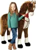 A young girl stands next to a large plush horse toy. Podgląd zdjęcia produktu