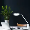 A desk setup with a laptop, a plant, and a desk lamp. Produktbild-Vorschau