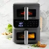 A dual-basket air fryer is shown on a countertop with some food items. Anteprima dell’immagine prodotto