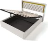 A white bed frame with the mattress support mechanism open, revealing storage space underneath. The headboard is upholstered in white tufted fabric with a yellow accent. Produktbild-Vorschau