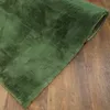 A close-up, angled view of a green rug with a soft, plush texture, lying on a wooden floor. Náhled obrázku produktu