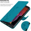 A teal phone case with a floral pattern is shown open, revealing a phone screen with a colorful abstract wallpaper. A close-up inset shows the magnetic closure detail. Náhled obrázku produktu