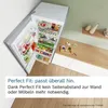 An open refrigerator filled with food, placed in a kitchen setting next to a wooden counter. Produktbild-Vorschau