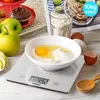 A kitchen scale with a bowl of ingredients for baking, along with apples and a muffin. Produktbild-Vorschau