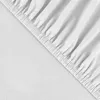 A close-up view of a white fitted sheet with elastic gathering along the edge. Produktbild-Vorschau
