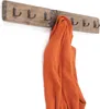 A wooden coat rack with hooks, with an orange sweater hanging on it. Náhled obrázku produktu