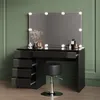 A black vanity table with LED lights and a stool in front of a green wall. Produktbild-Vorschau