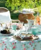 A table set for a picnic or outdoor meal with floral-patterned tableware and drinks. Produktbild-Vorschau