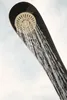 A close-up of a shower head with water spraying out, attached to a black object. Produktbild-Vorschau