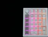 A white mechanical numpad with RGB lighting against a black background. Produktbild-Vorschau