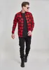 A man wearing a red and black checkered flannel shirt and black pants, standing against a white background. Produktbild-Vorschau