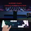 A close-up of a gaming keyboard with RGB lighting, with a hand interacting with it. The background shows a monitor and a game controller. Produktbild-Vorschau