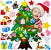 A child wearing a Santa hat is smiling and holding a felt Christmas tree with various felt ornaments. Voir les images du produit