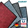 Multiple doormats are fanned out, overlapping each other, in different colors (red, light blue, dark gray). A marketing badge with a test result is in the bottom right corner. A 'Designed in Germany' seal is also visible. Náhled obrázku produktu