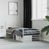 A white metal bed frame with bedding in a room. Podgląd zdjęcia produktu