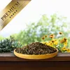 A wooden bowl filled with birdseed sits on a wooden surface, with a blurred background of greenery and yellow flowers. A golden ribbon with the word 'PREMIUM' and stars is overlaid in the top left corner. Produktbild-Vorschau