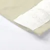 A close-up of a beige fabric with a white textured band attached. Produktbild-Vorschau