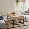 A living room scene with a coffee table, rug, and chair. Produktbild-Vorschau