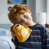 A young boy with red hair is holding a plush lion toy to his cheek. Voir les images du produit