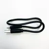 A black USB charging cable is laid out on a white textured surface. Produktbild-Vorschau