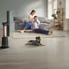 A couple and their dog relax in a living room with a fan. Podgląd zdjęcia produktu