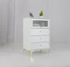 A white chest of drawers with a fluted glass top drawer and gold legs, set against a light gray and white background. Podgląd zdjęcia produktu