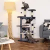 A cat tree with multiple levels and cats interacting with it, placed in a living room setting with a floor lamp and sofa. Náhled obrázku produktu
