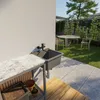An outdoor sink area next to a garden with a table and chairs. Anteprima dell’immagine prodotto