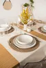 A dining table set for a meal with white ceramic dishes, glassware, and a floral centerpiece. Voir les images du produit