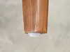 Close-up of the bottom of a wooden furniture leg with a white protective cap. Voir les images du produit
