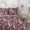 A bedroom scene with a bed dressed in paisley patterned bedding. Produktbild-Vorschau
