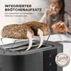 A woman is eating a croissant while a toaster with bread on top is shown in the foreground. Produktbild-Vorschau