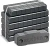 A stack of dark gray briquettes, with one briquette in the foreground showing the brand name. Produktbild-Vorschau