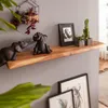 A wooden shelf mounted on a gray wall, decorated with elephant figurines, plants, and framed pictures. Anteprima dell’immagine prodotto