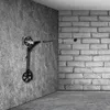 A black scooter is mounted vertically on a textured gray wall, with a white brick wall in the background. Náhled obrázku produktu