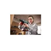 A woman is using a cordless drill to drill into a wooden surface in a workshop. Produktbild-Vorschau