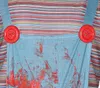 Close-up of a child's striped shirt and denim overalls with red buttons and red splatters. Podgląd zdjęcia produktu