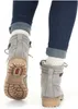 A close-up view of a person's legs wearing jeans, white socks, and gray ankle boots. Anteprima dell’immagine prodotto