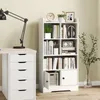 A white bookshelf with books and decorative items is shown next to a desk with a lamp and drawers. Produktbild-Vorschau