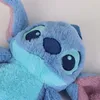 Close-up of a blue plush toy character with pink accents. Voir les images du produit